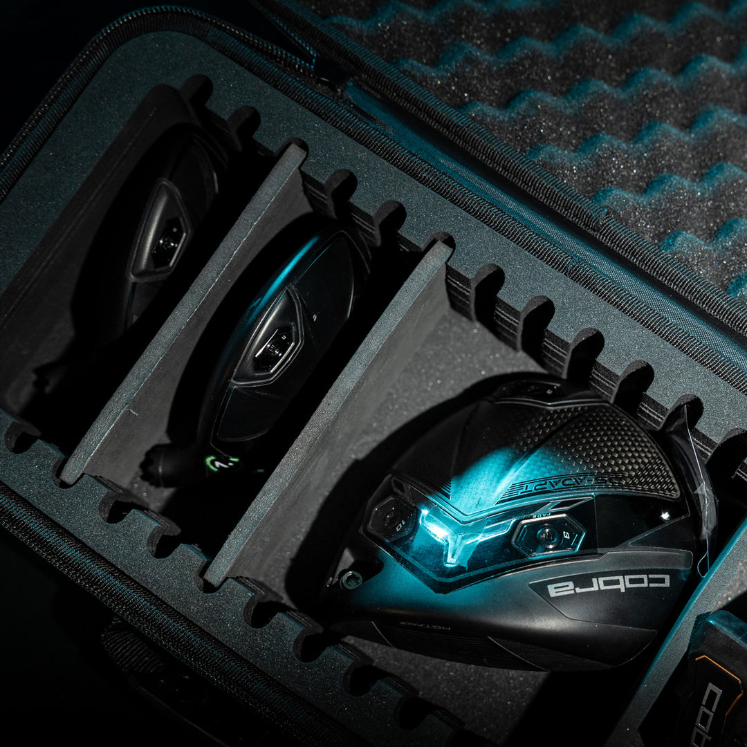 Cobra black golf driver heads in protective case, featuring sleek design and vibrant blue accents, perfect for performance.