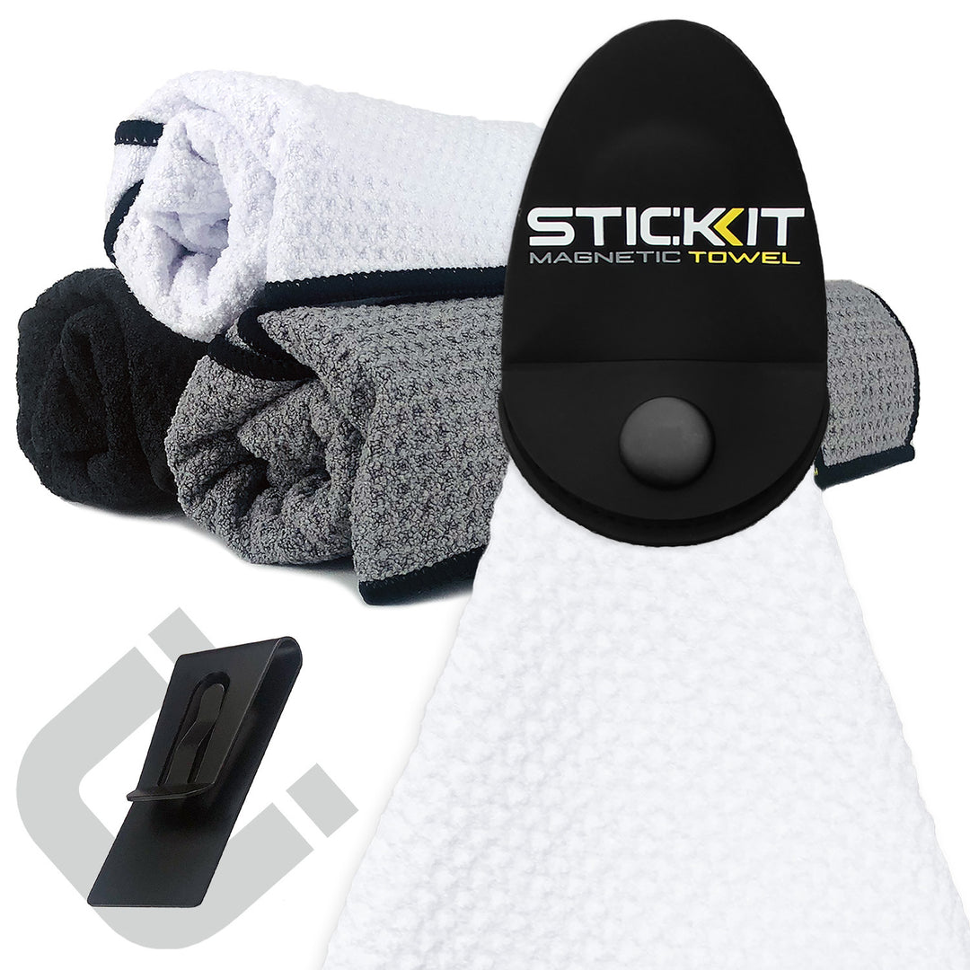 White magnetic towel with black holder, surrounded by gray and black textured towels, ideal for sports and outdoor use.