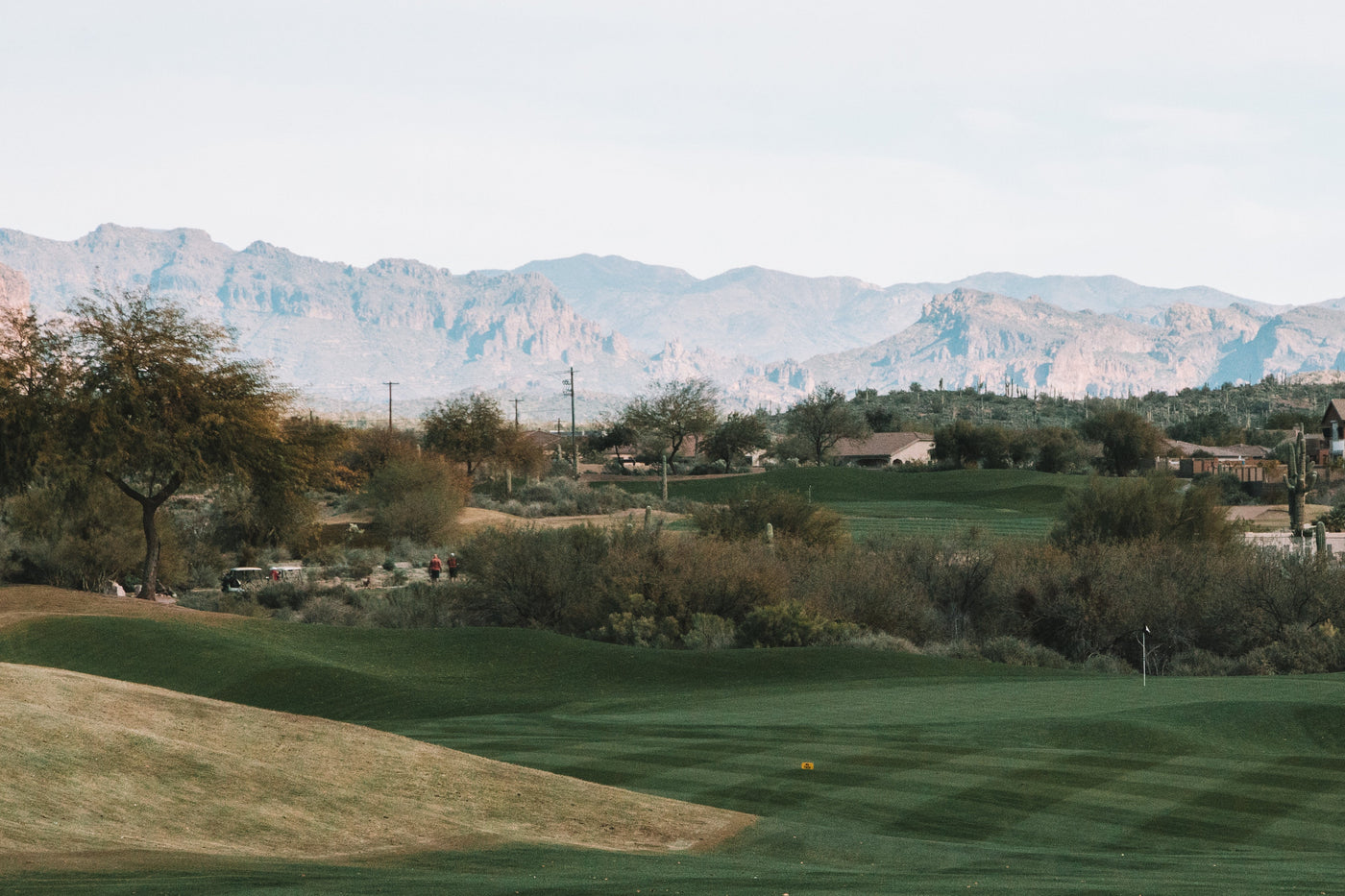 Scenic golf course with lush green grass and mountains in the background, ideal for golf enthusiasts.