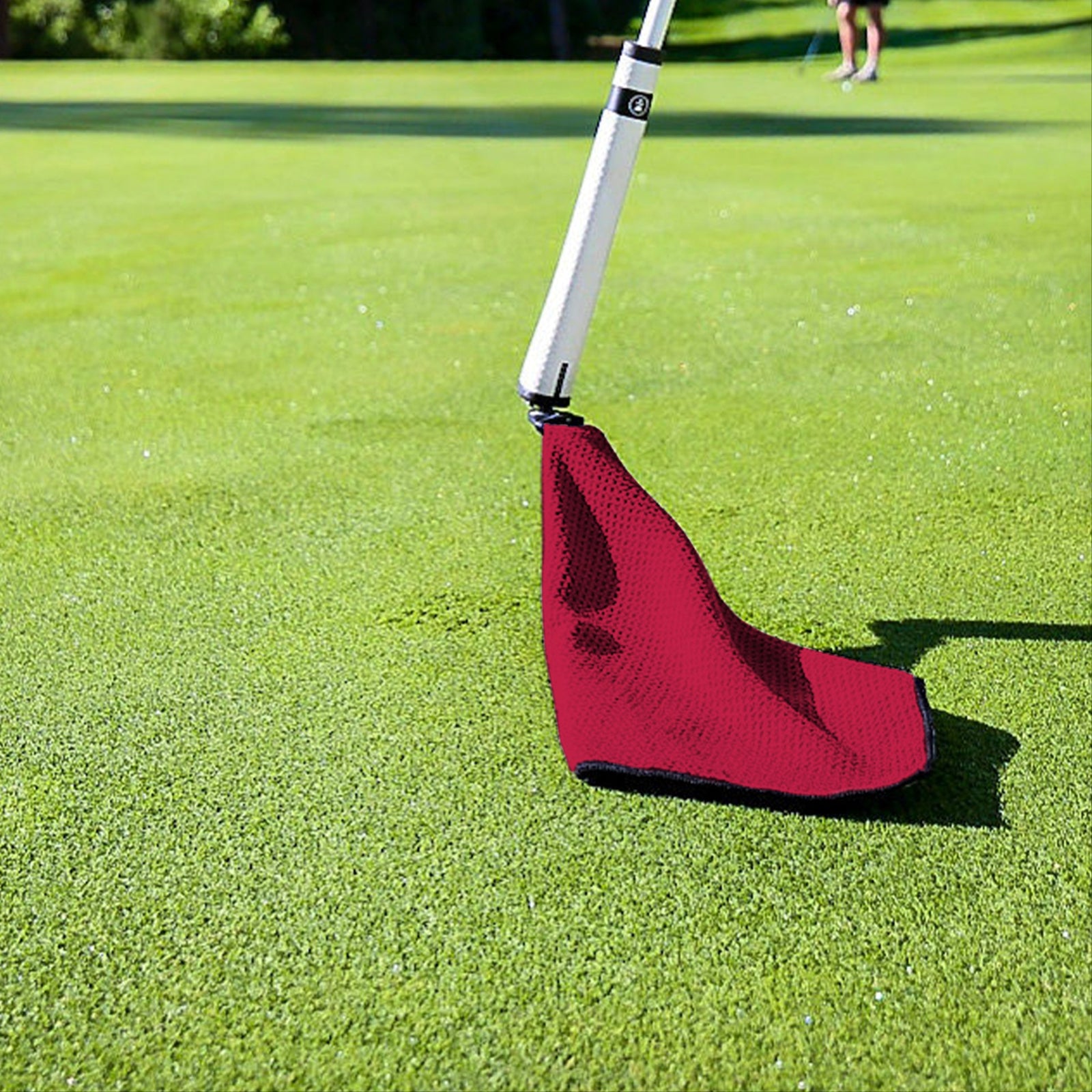 Red golf practice putting green mat with white golf club, designed for indoor-outdoor use.