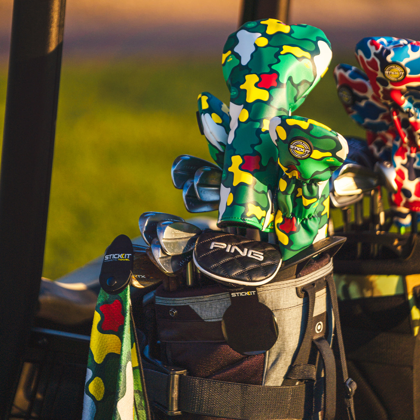 Colorful camo golf club headcovers, green, yellow, and red, paired with a sleek black golf bag.