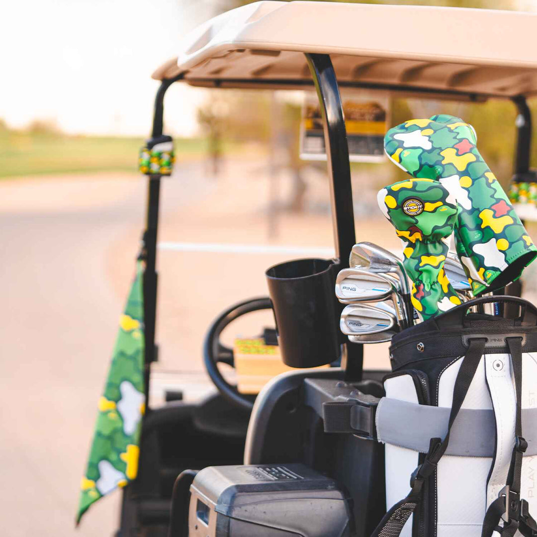 Golf cart with STICKIT Augusta Collection camo headcovers and magnetic golf towel attached, featuring green camo golf accessories on course