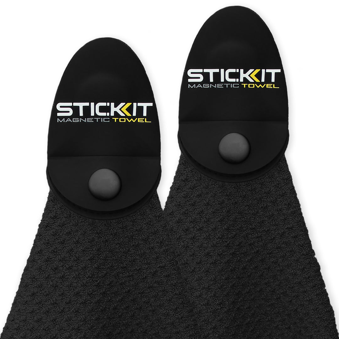 Black magnetic towel with textured fabric and unique button closure, ideal for gym and outdoor use. Stylish and functional.