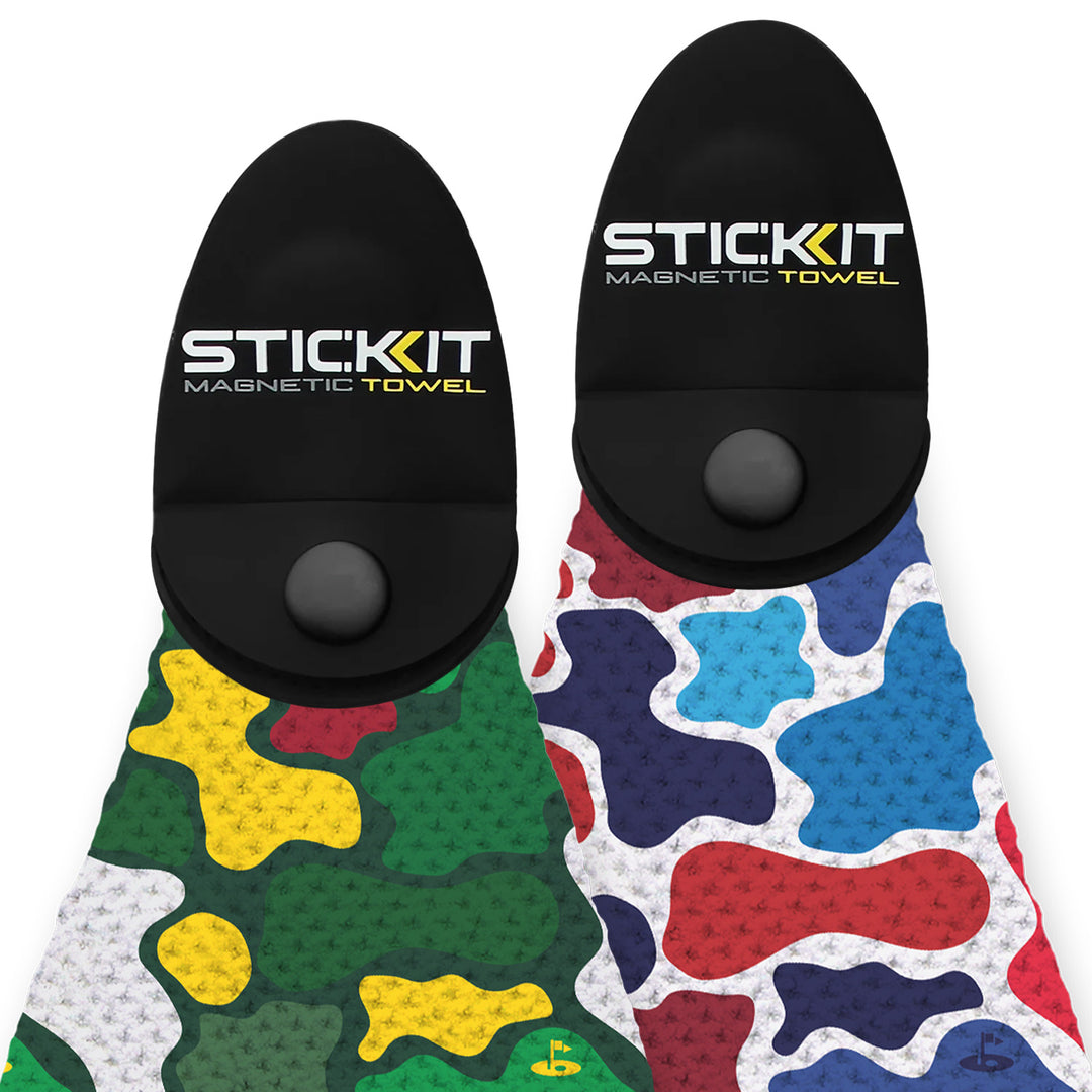 Dual pack of STICK:KIT magnetic towels in green camo and red/blue splatter patterns with black magnetic holder.