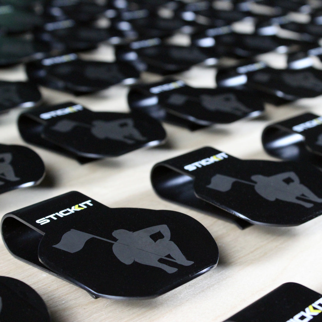 Black Stickit clips with logo, durable plastic material, perfect for organizing and displaying items.