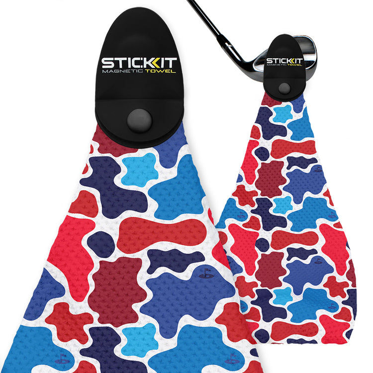 Colorful red, blue, and white camo-patterned magnetic golf towel with black clip and textured fabric.