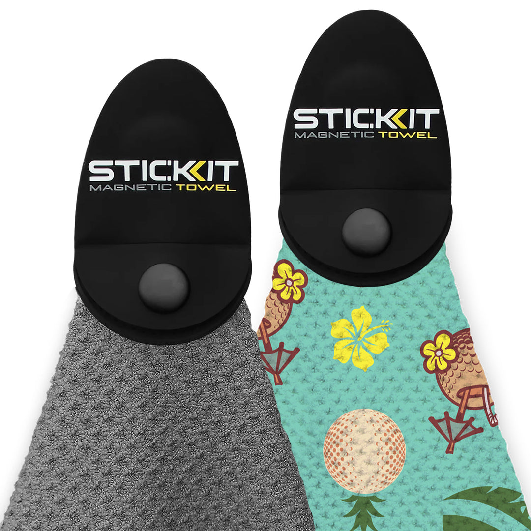 Two STICKIT magnetic towels: one gray, one teal with tropical print, featuring a secure black magnetic holder.