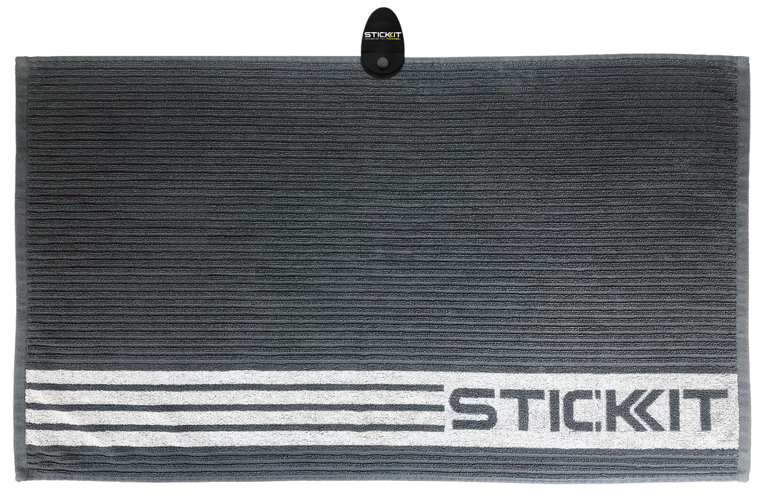 Gray striped microfiber towel with "STICKIT" logo, perfect for workouts and sports activities. Lightweight and absorbent.
