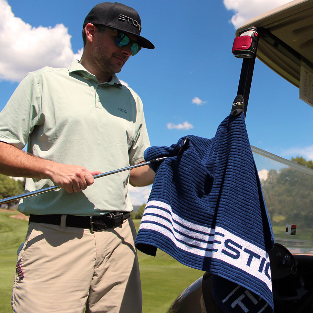 Stylish navy golf towel with white stripes, made from soft, absorbent material, perfect for on-course use.