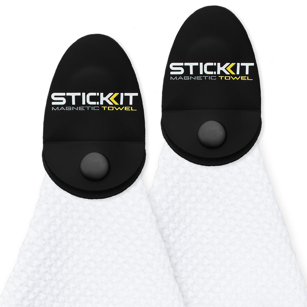 Black magnetic towel holder with white plush towel, featuring "STIC:KIT" logo in yellow and gray, ideal for outdoor use.
